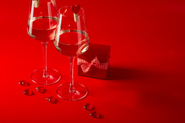 Two full glasses of wine over red background