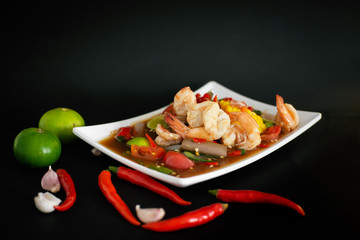 Spicy papaya salad with shrimp, and hot chilli, Thai food in white dish on black background