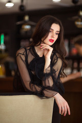 portrait of a beautiful young woman in a black dress indoors