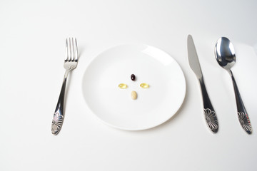 Meal replacement. Multivitamin and mineral supplements. Fish oil, vitamins and astaxantnin, omega. Table set with tablets.  First person view.