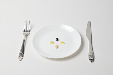 Meal replacement. First person view. Multivitamin and mineral supplements. Table set with tablets. Fish oil, vitamins and astaxantnin.