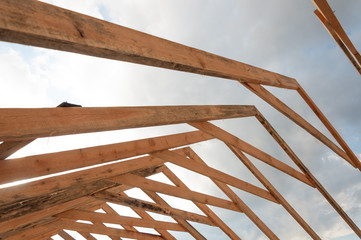 Installation of wooden beams. Rafter system on the roof on a sky background