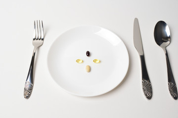 Multivitamin and mineral supplements. Table set with tablets. Meal replacement. First person view. Astaxanthin.