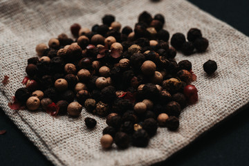 Aromatyczny kolorowy pieprz na lnianym woreczku, przyprawa na czarnym tle