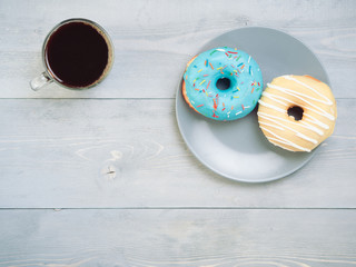 donuts and coffee on gray wooden background, copy space, top view