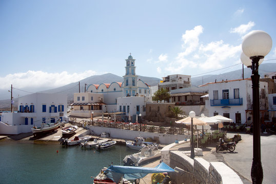 Kassos island, Greece.  The old harbour.  Fishing and pleasure boats at the dock.  The bell tower of the town church is by the port.