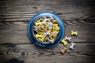 Dog food in bowl on wooden table