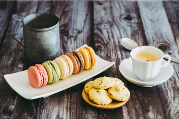 Café avec macarons colorés et biscuits cannelle