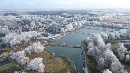 Frozen like. Aerial drone overhead flying over river ice with forest in winter.