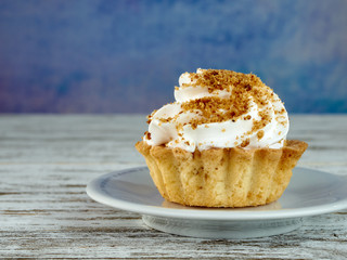 Shortcrust pastry with beaten cream.Cup of coffee, tea.On a colored background