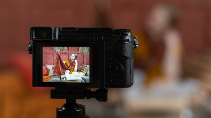 Young adult vlogger recording video on dslr camera