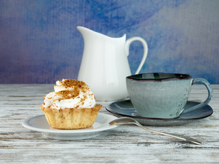 Shortcrust pastry with beaten cream.Cup of coffee, tea.On a colored background