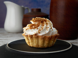 Shortcrust pastry with beaten cream.Cup of coffee, tea.On a colored background