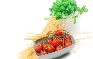 dynamic perspective of a bowl with cherry tomatoes with pasta and basil plant with white background