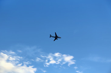 Airplane in the blue sky with clouds
