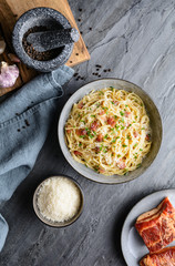 Classic pasta Carbonara, hearty Italian dish made with Spaghetti, egg, fried bacon, topped with grated Parmesan cheese and black pepper