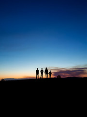 silhouette of people on top of the mountain at sunset