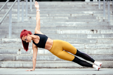Athletic woman doing sports training, side planks and jogging outdoors