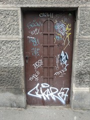 Graffiti tagged metal door in concrete wall