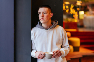 Content Young Asian Man Drinking Coffee in Cafe