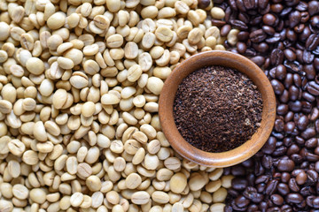 High angle view, White dried coffee beans and roasted coffee beans with powder coffee in wooden bowl.