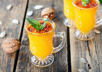 Healthy pumpkin fruit smoothie with seeds and mint leaves on table