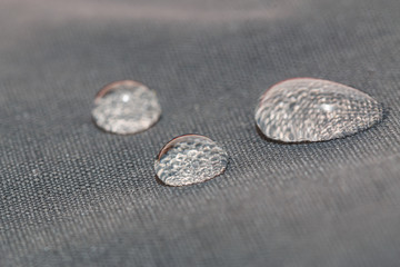 Rain water droplets on a  waterproof fabric gray background