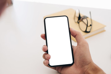 Top view man sitting and holding blank screen mock up mobile phone
