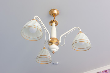 A chandelier on the ceiling with snare ceilings, close-up