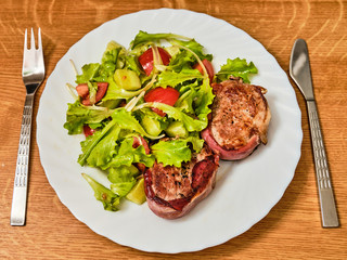 Pork tenderloin in dried ham  steak with salad