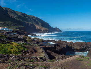 Fototapeta na wymiar View on La Fajana with natural sea swimming pools and waves of atlantic ocean, sunny day. La Palma, Canary Islands, Spain