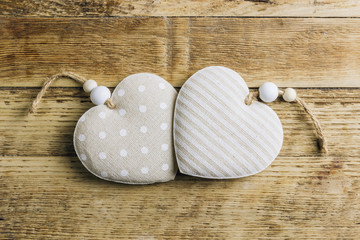 Rustic Valentines day background with toy hearts over wooden table. Place for text.