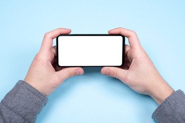 Black smartphone in men's hands. The phone is horizontal with a white screen. Mockup phone