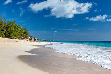 Looking along the idyllic Elbow Beach on the island of Bermuda, with a blue sky overhead