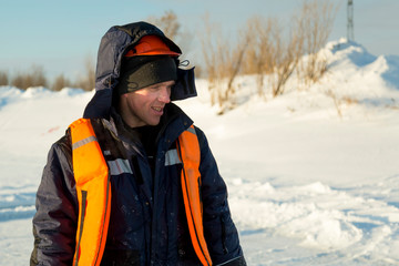 Fototapeta na wymiar Worker in an orange helmet with a hood on his head