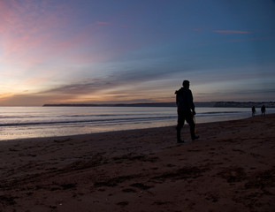 dog walkers on the beach at dawn