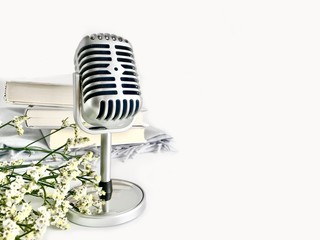 A classic silver microphone on white copy space background. Concept of Podcast and audio books.