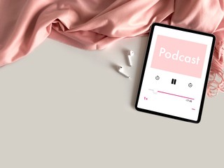 Background with copy space for Podcast concept. A tablet playing Podcast on cozy pink fabric background.