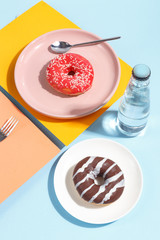 Various sweets, doughnuts, bagels, muffins and drinks on a multi-colored background. Bright colors, the concept of the holiday.