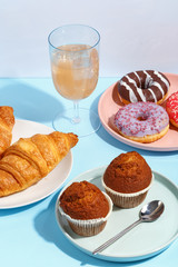 Various sweets, doughnuts, bagels, muffins and drinks on a multi-colored background. Bright colors, the concept of the holiday.