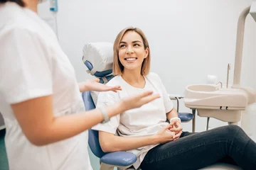Foto auf Acrylglas Zahnärzte Junge schöne Dame mit blonden kurzen Haaren sitzt in der Zahnarztpraxis und wartet auf eine Zahnbehandlung. Medizin, Zahnarztkonzept