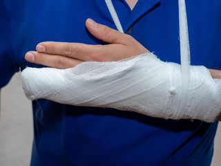 ..Close up hand of man with bandage and gypsum. a broken plastered arm after accident.