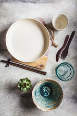 Empty crockery background. Pottery empty bowl and plate on gray background. Table setting concept.
