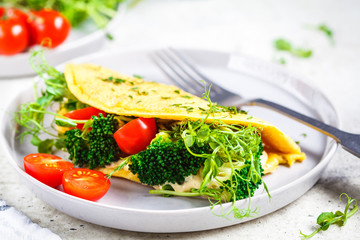 Omelet with broccoli, tomatoes and seedlings. Healthy vegan food concept.
