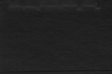Cardboard black abstract texture close-up. Dark old paper background. Grunge concrete wall. Vintage blank wallpaper.