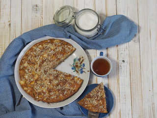 Sliced slice of apple pie with crushed walnuts. Homemade baking.
