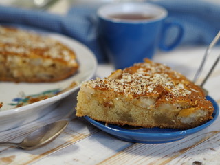 Sliced slice of apple pie with crushed walnuts. Homemade baking.