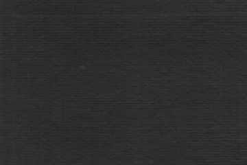 Cardboard black abstract texture close-up. Dark old paper background. Grunge concrete wall. Vintage blank wallpaper.