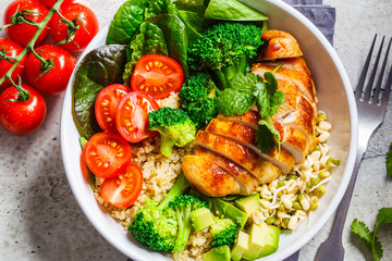 Balanced food concept. Chicken, broccoli and quinoa salad in white bowl, gray background.