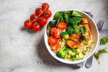 Balanced food concept. Chicken, broccoli and quinoa salad in white bowl, gray background, top view.